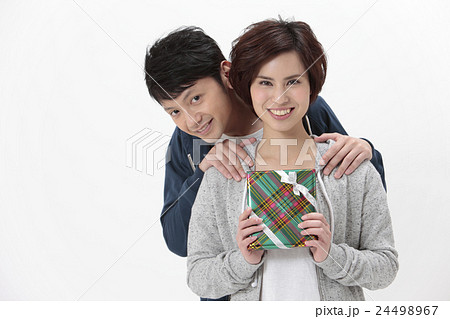 プレゼントを持つカップルの写真素材