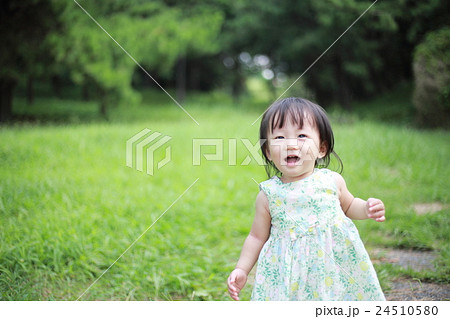 赤ちゃん ベビー 幼児 女の子 1才 1歳 公園 歩く 歩行 よちよち歩き 楽しい 笑顔 元気 の写真素材
