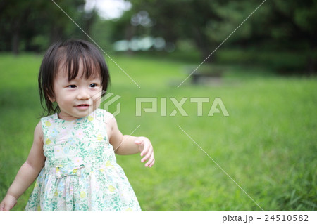 赤ちゃん ベビー 幼児 女の子 1才 1歳 公園 歩く 歩行 よちよち歩き 楽しい 笑顔 元気 の写真素材