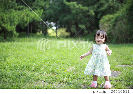 赤ちゃん ベビー 幼児 女の子 1才 1歳 公園 歩く 歩行 よちよち歩き 楽しい 笑顔 元気 の写真素材