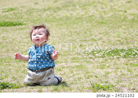 赤ちゃん 膝立ち 芝生 の写真素材