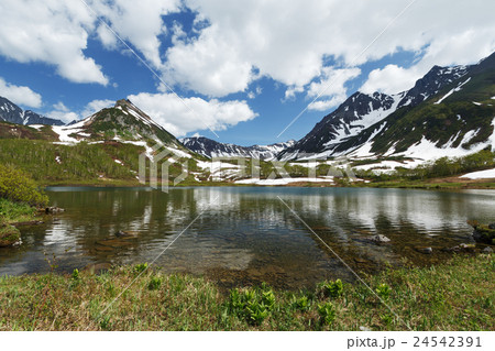 Mountains, mountain lake and clouds in blue sky Mountains, mountain lake and clouds in blue sky 24542391