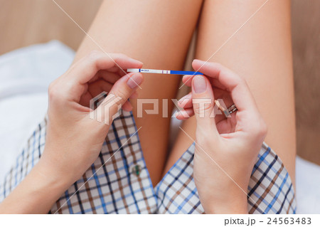 Woman on bed with positive pregnancy test in hands Woman on bed with positive pregnancy test in hands 24563483