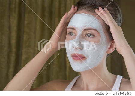 woman doing cosmetic mask on her face 24564569