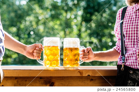 Men in traditional bavarian clothes holding mugs 24565800