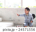 笑顔で指差して座っている男の子 24571556