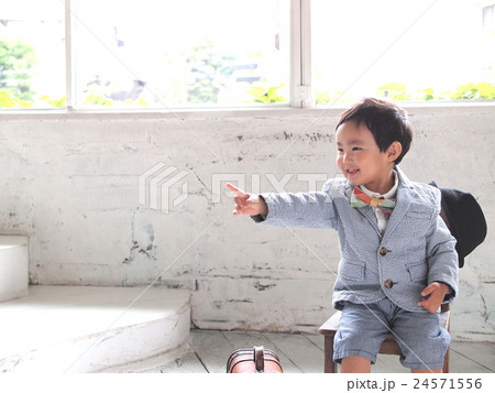 笑顔で指差して座っている男の子 24571556