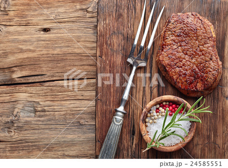 Beef steak on a wooden board with spices 24585551