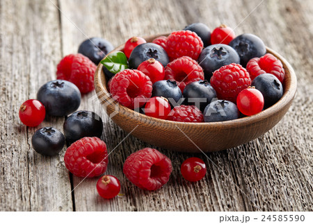 Ripe berry in a wooden plate 24585590