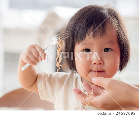 Happy Asian child eating delicious noodle Happy Asian child eating delicious noodle 24587098