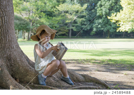 木陰で本を読む女の子の写真素材 2454