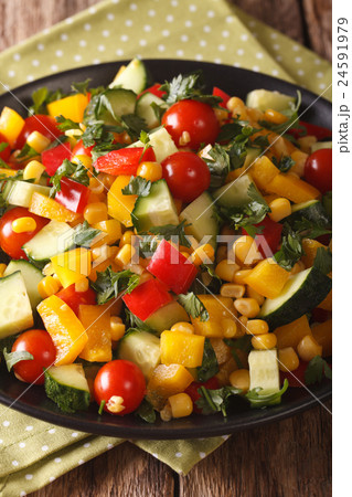 salad of corn, greens, tomatoes, cucumbers 24591979