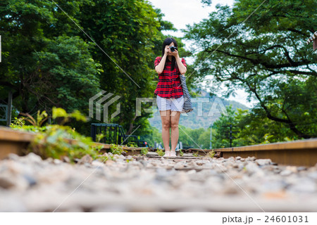 Photographer with mirrorless camera on railway 24601031