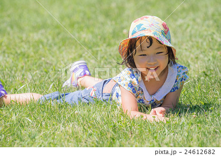 芝生の上で遊ぶ小さな女の子の写真素材