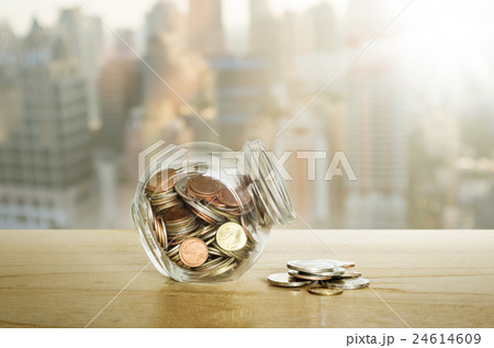 Money in the glass bottle on wooden table. Money in the glass bottle on wooden table. 24614609
