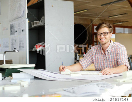 Architect works on drawing table in studio. Architect works on drawing table in studio. 24617143
