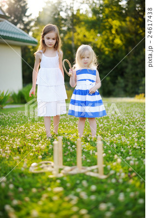 Two cute little sisters playing ring toss game 24617438