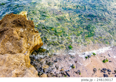wave rolls onto the rocks of sandy coast wave rolls onto the rocks of sandy coast 24619017