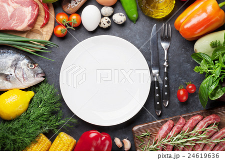 Empty plate surrounded by cooking ingredients 24619636