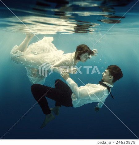 Woman and man swimming underwater Woman and man swimming underwater 24620979