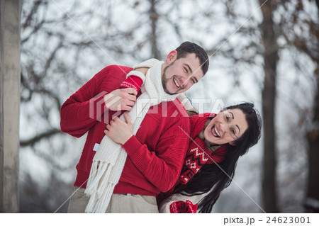 man and woman having fun in the snow-covered park man and woman having fun in the snow-covered park 24623001