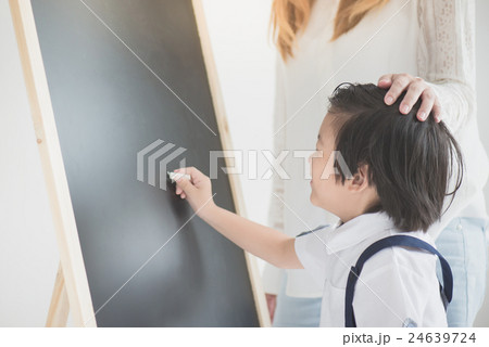 Cute Asian child writing on blackboard with Cute Asian child writing on blackboard with 24639724
