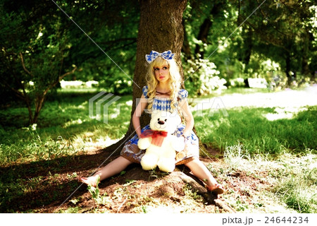 Portrait of young woman dressed as doll, near tree 24644234
