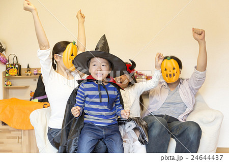 家族で楽しいハロウィン イメージ ガッツポーズ 叫ぶ 室内リビング ソファーに4人の写真素材