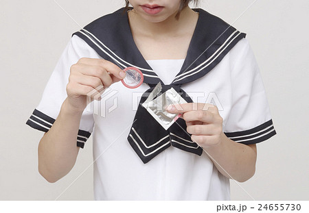コンドームを持つ女子高生の写真素材