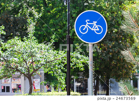 Blue bicycle lane sign with trees background 24673569
