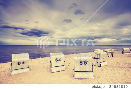Hooded wicker chairs on an empty beach. Hooded wicker chairs on an empty beach. 24682819