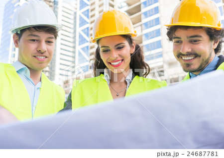 Architects with ground plot on construction site 24687781