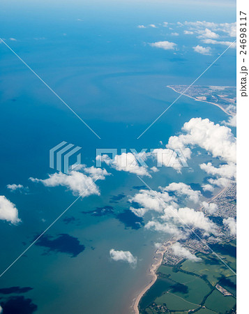 空から見た海岸線と海に映る白い雲の影の写真素材