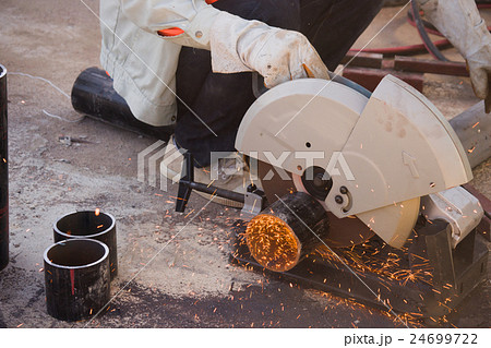 electric saw and hands of worker with sparks. 24699722