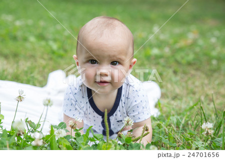 Baby girl crawling on the grass. Selective focus Baby girl crawling on the grass. Selective focus 24701656