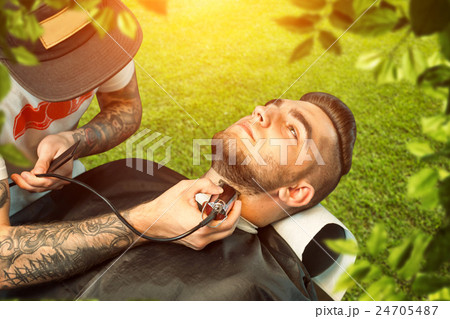 Young man having beard shaven Young man having beard shaven 24705487