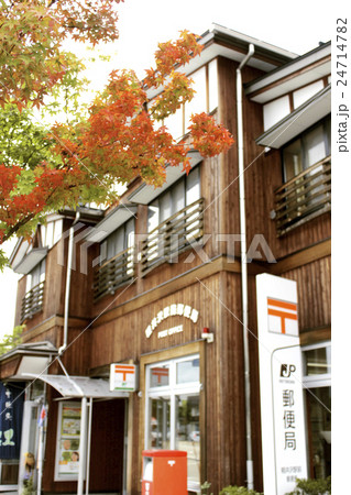 赤く紅葉したモミジと、都市景観になじんだ木造の郵便局の建物 赤く紅葉したモミジと、都市景観になじんだ木造の郵便局の建物 24714782