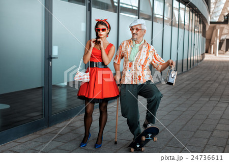 Old man saunters with a young girl. 24736611