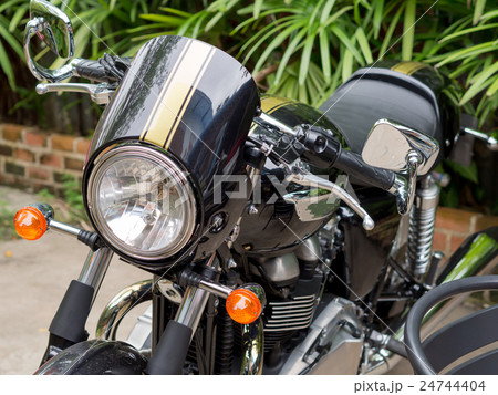 Motorbikes are large and black, vintage style . Motorbikes are large and black, vintage style . 24744404