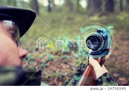 close up of soldier or sniper with gun in forest 24750340