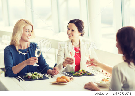 happy women drinking champagne at restaurant happy women drinking champagne at restaurant 24750972