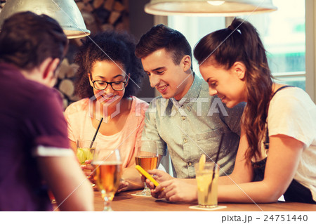 happy friends with smartphones and drinks at bar 24751440