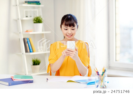happy young woman student with smartphone at home 24751746