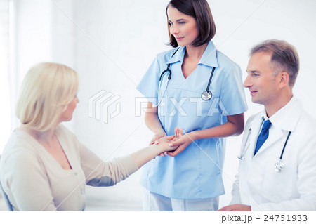 nurse with patient measuring pulse 24751933
