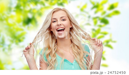 smiling young woman holding her strand of hair smiling young woman holding her strand of hair 24752450