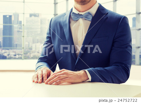 close up of man in suit and bow-tie at table close up of man in suit and bow-tie at table 24752722