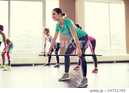 group of people exercising with bars in gym group of people exercising with bars in gym 24752765
