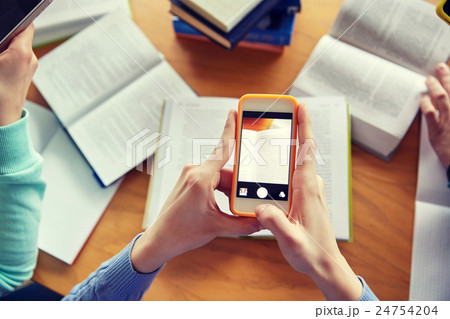 students with smartphones making cheat sheets 24754204