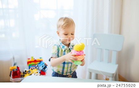happy little baby boy with ball clay at home 24755020