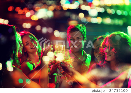 smiling friends with glasses of champagne in club 24755100